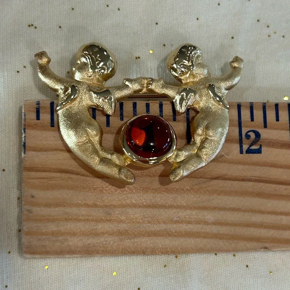New Vintage Louis Stern (LS) gold-tone cherub brooch with a faux amber cabochon.